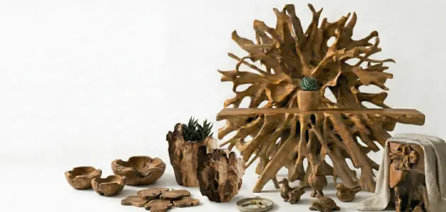 A solid teak root console table surrounded by rustic wooden planters, bowls, coasters, and carved animal figurines.